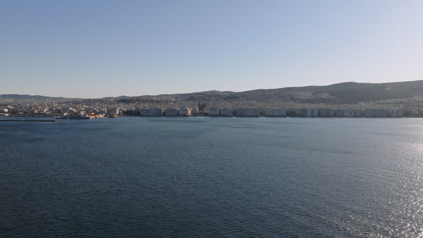 Aerial view across calm harbor waters toward Thessaloniki