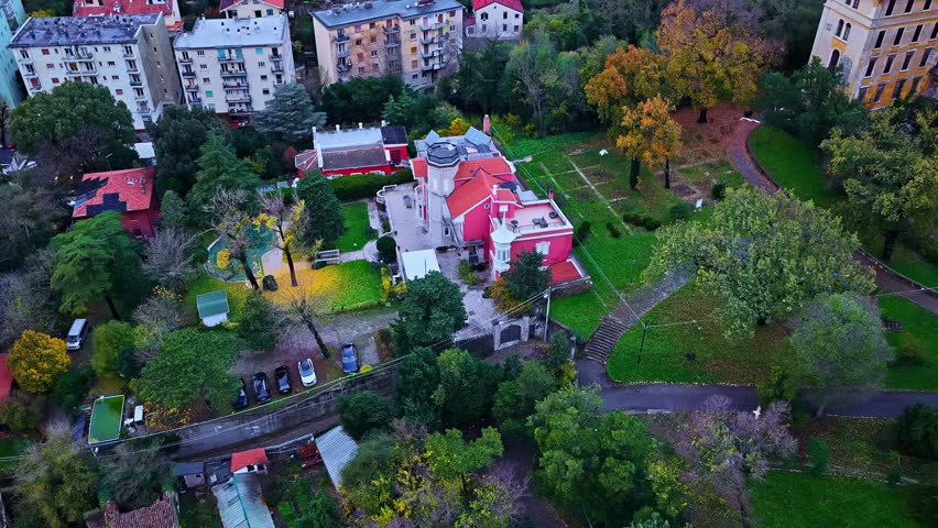 Aerial view of an old building with a large, flower filled courtyard in Trieste, Italy.