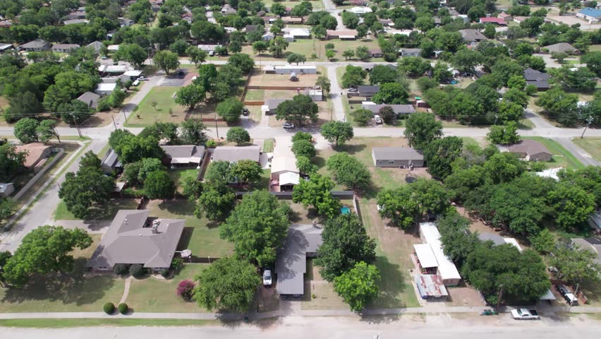 Aerial video of the city of Henrietta, Texas. Camera flies at a medium speed over houses and streets.