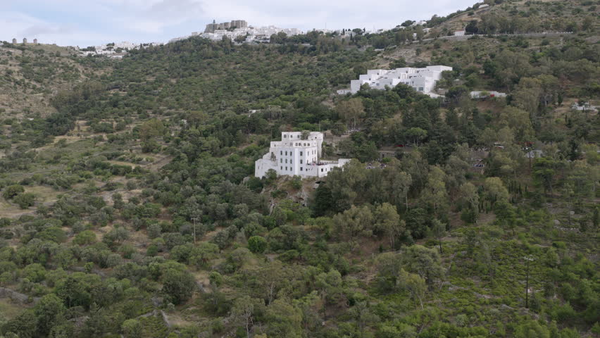 Aerial view of a whitewashed monastery complex nestled in Patmos