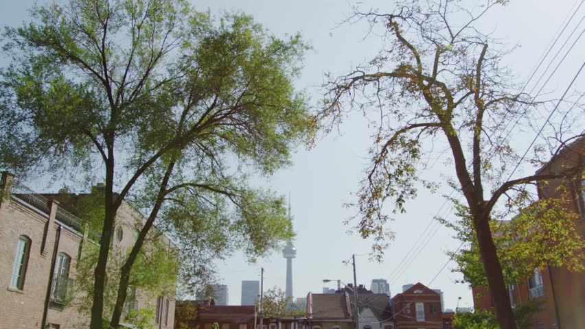 establishing shot of Toronto Tower Viewed Through Tree-Lined Residential Neighborhood in Downtown Toronto Ontario Canada