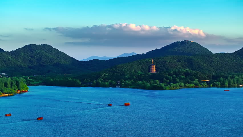 Aerial view of West Lake surrounded by lush green mountains in Hangzhou, China.