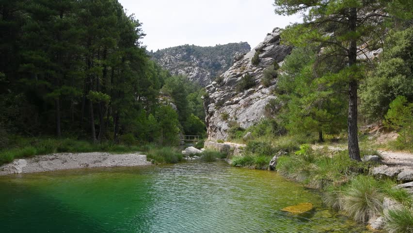 Scenic Wooden Boardwalk Along Crystal Clear River Stream in Canyon