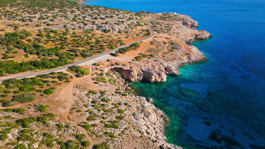 Drone view of the rocky shoreline in Cavo Greco National Park, Cyprus. Clear blue water, rugged limestone cliffs and coastal trails create a beautiful nature panorama.