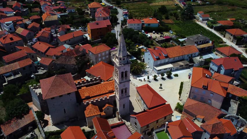 Beautiful aerial perspective of the historic parish of the assumption of mary church in jelsa, showcasing its bell tower and the village