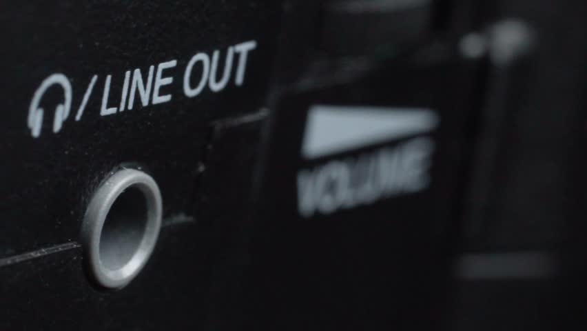 Macro close up showing line out audio connector beside line in port on electronic device with shallow depth of field highlighting analog sound interface and connection details