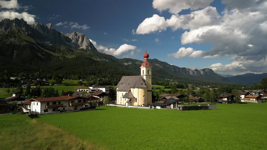 Red Roofed Church in front of a Picturesque Alpine Landscape in Going am Wilder Kaiser, Austria