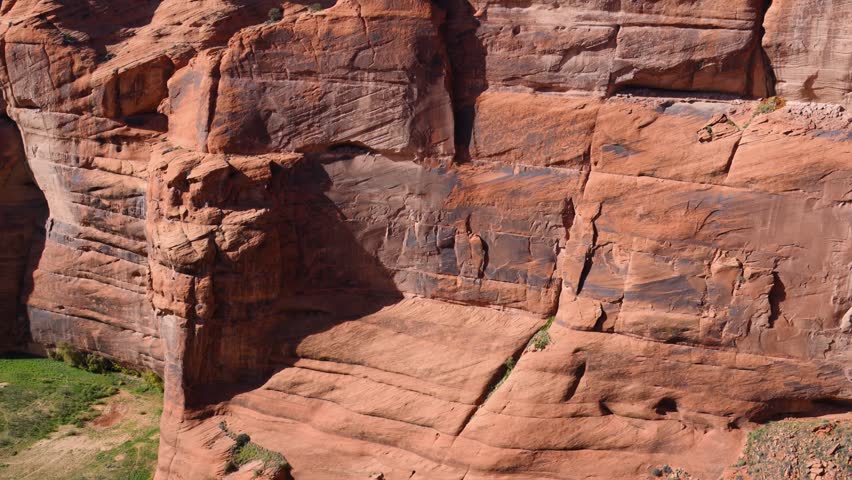Landscape of Canyon de Chelly National Monument, located near Chinle, Arizona, USA. The principal attraction is Antelope House Overlook, which offers panoramic views of the canyon system and the archaeological ruins of Antelope House, an ancestral Puebloan cliff dwelling. The dark streaks visible on the sandstone canyon walls are known as desert varnish, a natural surface coating composed primarily of manganese and iron oxides. Navajo families continue to reside within the canyon, practicing traditional livestock husbandry and agriculture in accordance with their cultural heritage. Arizona, USA.