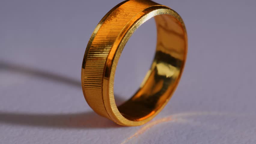 Close-up rotating shot of a gold ring, symbolizing gold price, investment value, and precious metal trading in the financial market.