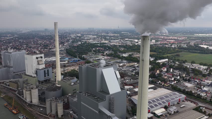 A drone view of the Mannheim coal-fired power plant releasing steam above the city, showing large-scale energy infrastructure in Germany