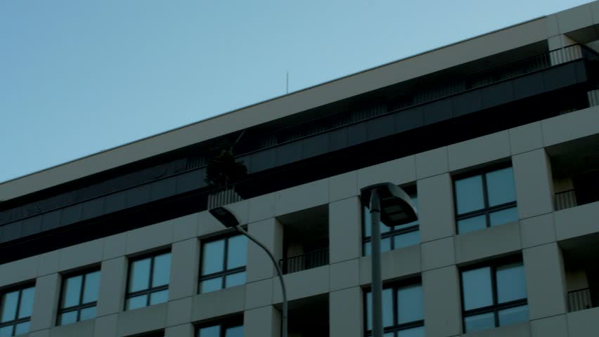 Low angle shot of modern building facade featuring curved balconies and sleek architectural lines in Gdynia, Poland