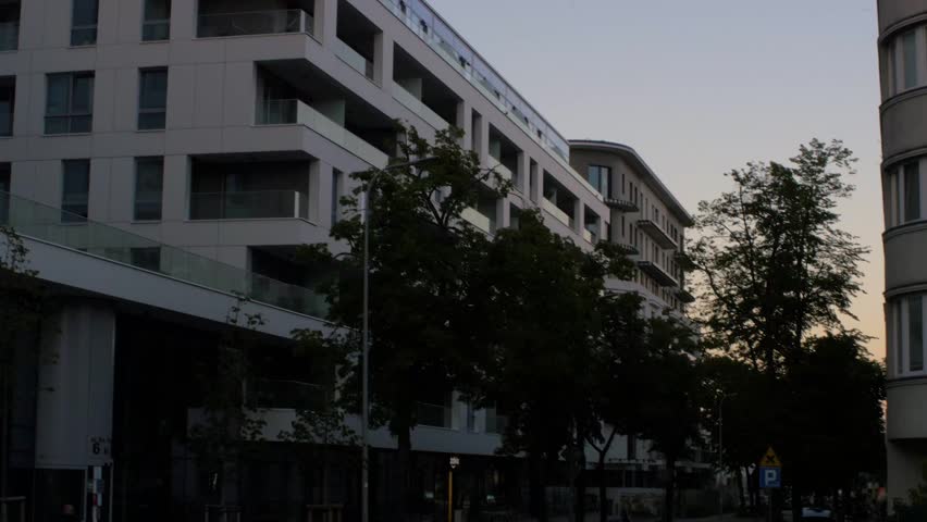 Wide angle exterior shot of contemporary apartment building with white facade and glass balconies in Gdynia, Poland
