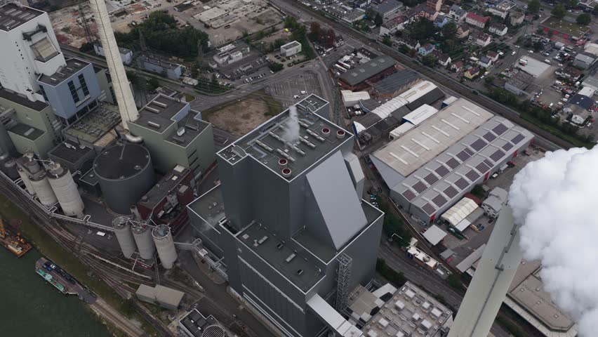 A detailed aerial view of the Mannheim Power Plant in Baden-Wurttemberg, Germany, showing steam stacks, industrial roofs, and the vast energy complex