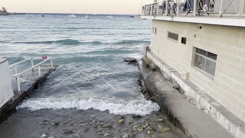 a stretch of beach on the Otranto waterfront bordered by a restaurant building built right on the sea