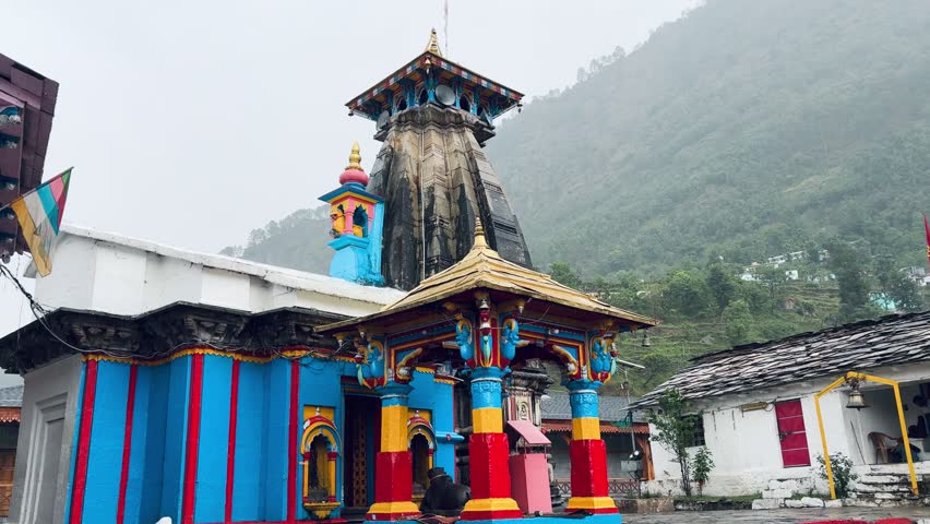 Ancient Omkareshwar Temple in Ukhimath, Uttarakhand, India, featuring traditional Himalayan architecture against misty mountain slopes, a revered winter seat of Lord Kedarnath.
