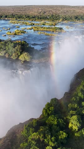 Rainbow In Waterfall At Victoria Falls In Matabeleland North Zimbabwe. Giant Waterfalls. Nature Landscape. Victoria Falls At Matabeleland North Zimbabwe. Zambezi River. Travel Scenery.