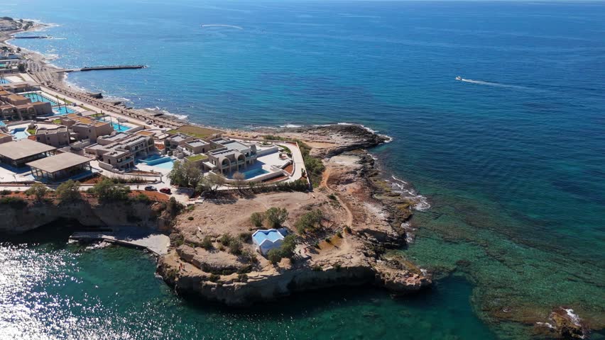 Chapel with blue roof on cliff, aerial view from Greek island