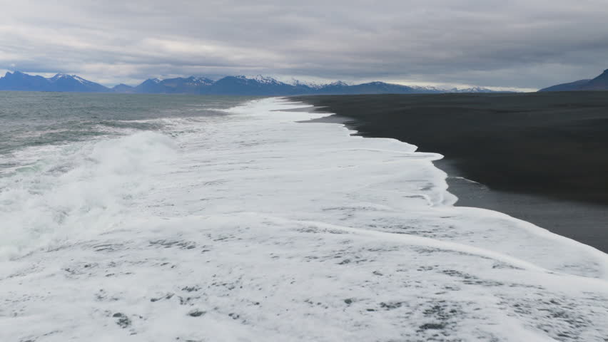 Aerial view of ocean crashing on the beach. black sand. Iceland