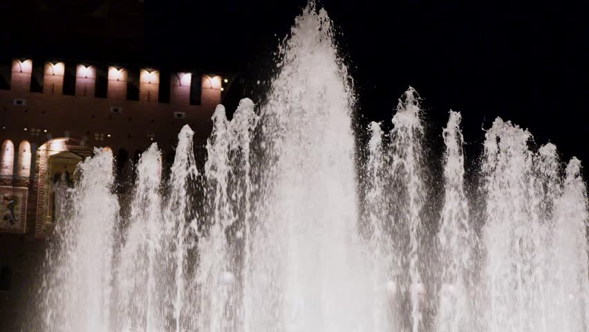 Water fountain in front of building at night
