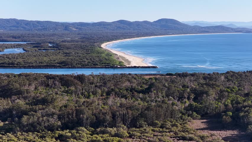 Wide aerial shot of a river meeting the ocean at South West Rocks, Australia.