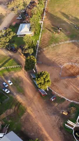 High-angle drone shot of a country rodeo arena and horse paddocks in Coonabarabran, Australia.