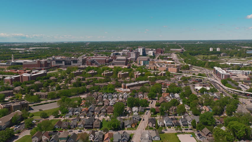 American residential neighborhood in Indianapolis: rows of single-family homes under mature trees, with the city
