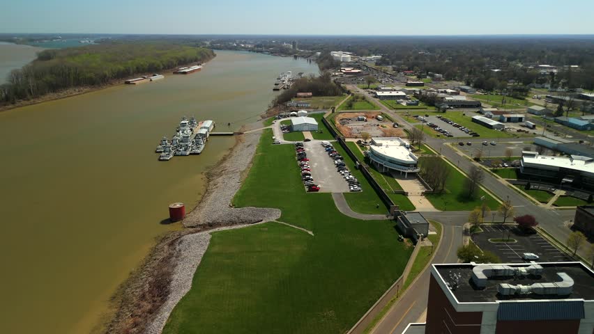 Top down view of a riverside park and building complex beside a river bend