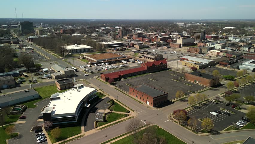 Wide aerial view overlooking a commercial district with stores and busy roadways