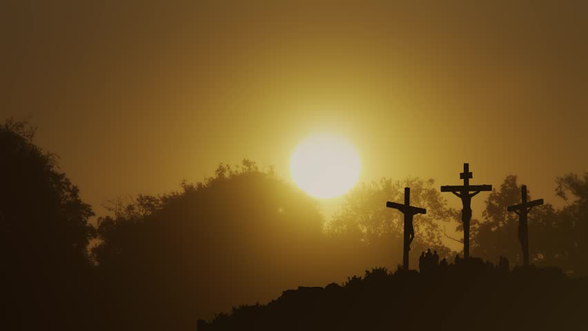 Silhouette of three crosses on Calvary at sunset with people gathered, Good Friday stock footage.
A powerful, cinematic silhouette of the crucifixion scene on Calvary hill during a dramatic golden sunset. The central cross of Jesus Christ is positioned directly in front of the setting sun, creating a striking halo effect, flanked by the two thieves. A small crowd of silhouettes is gathered at the base of the crosses in mournful observation. This high-quality conceptual footage is ideal for Easter services, Good Friday presentations, religious documentaries, and Christian faith-based media projects.