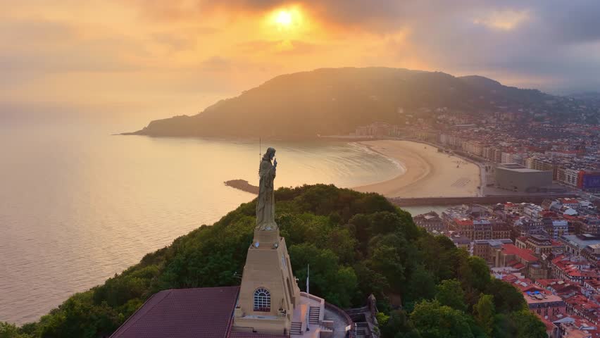 Sunrise drone view of San Sebastián, Basque Country, Spain, famous Jesus Christ statue on a hill in San Sebastián, vacation in northern Spain
