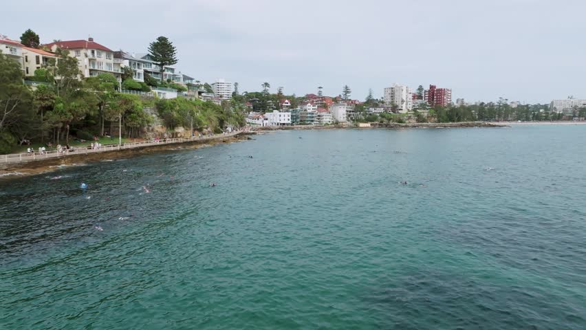 Cinematic Drone Flight Along Shelly Beach Waterfront Revealing Crystal Clear Ocean, Coastal Walk, Luxury Homes and Sydney Harbour Shoreline in Manly Australia