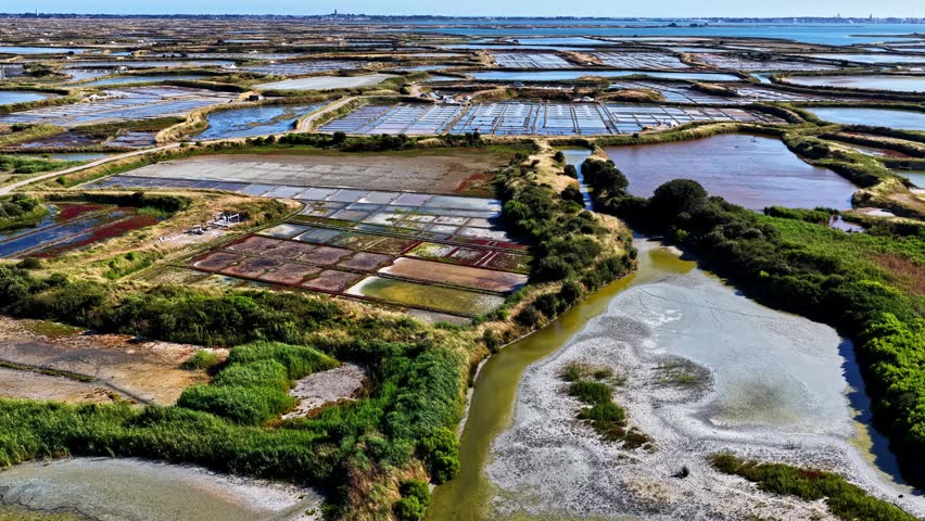 Aerial view of salt marshes with geometric pools and water channels in Capbreton, Nouvelle-Aquitaine, France.