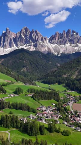 Vertical aerial drone view of Santa Maddalena (Magdalena) village with the Dolomite mountains in the background. Val di Funes valley, Trentino-Alto Adige region. Italy, Europe.