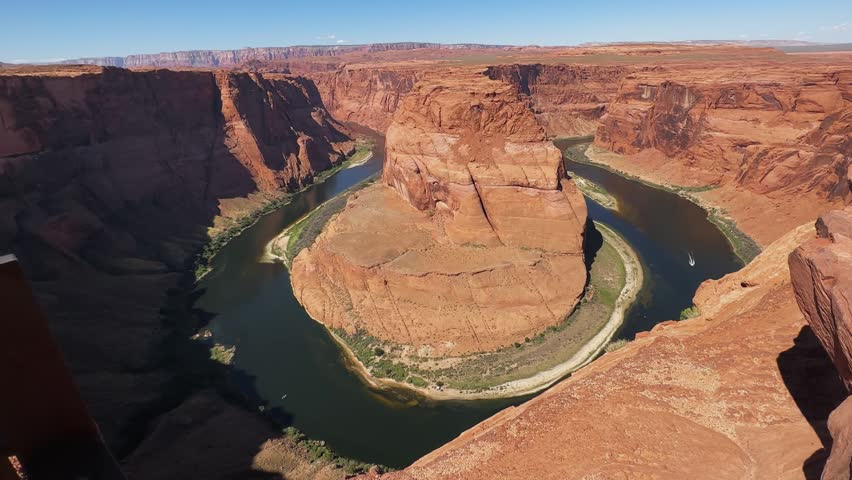 Stunning panoramic view of the iconic Horseshoe Bend, a U shaped meander of the Colorado River, carved into the red rock landscape near Page, Arizona. Captures the vast natural beauty of the American Southwest.
