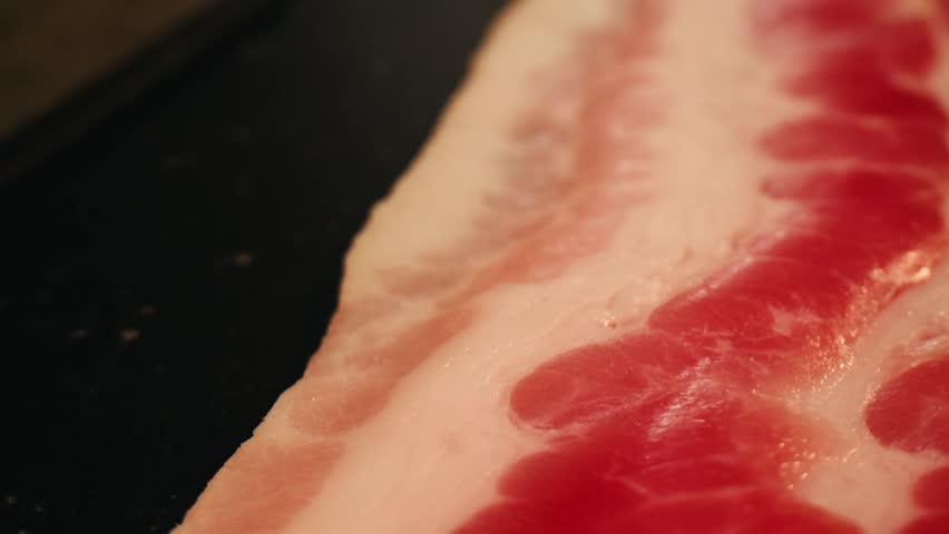 Sliced ham jamon fat bacon meat, beef pastrami thick pieces on a wooden board, beef or pork jamon. Chef cooking breakfast, smoked bacon in cafe. 