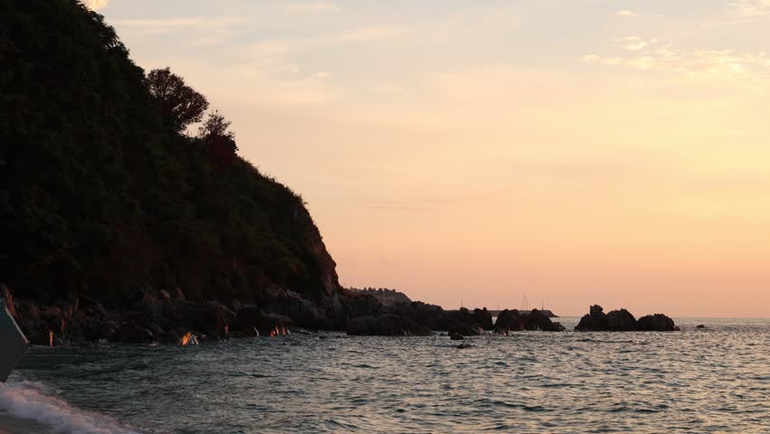 Silhouetted Cliff and Rocky Coastline at Dusk Near Tropea