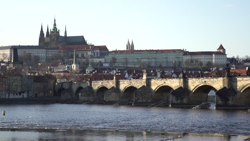 iconic Charles Bridge over Vltava River with view of Prague Castle and St Vitus Cathedral in winter wide shot  panorama.