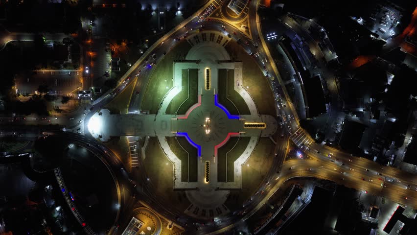 Aerial view of the illuminated Plaza de la Bandera at night with its distinctive cross-shaped layout and surrounding traffic in Santo Domingo, Santo Domingo Provinc, Dominican Republic.