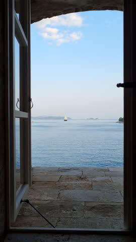 Looking through historic stone window at Adriatic sea and  cruise ship on the horizon in Dubrovnik, Croatia.