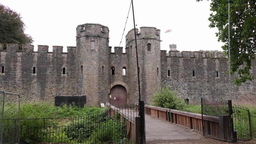 Wooden bridge leading to the historic Black Gate entrance of Cardiff Castle, a medieval fortress in Wales, United Kingdom, exhibiting stone walls and defensive towers