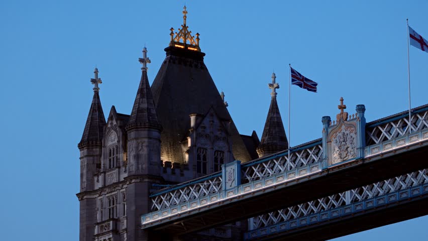 Union Jack flag waving on Tower Bridge in London, United Kingdom, at sunset