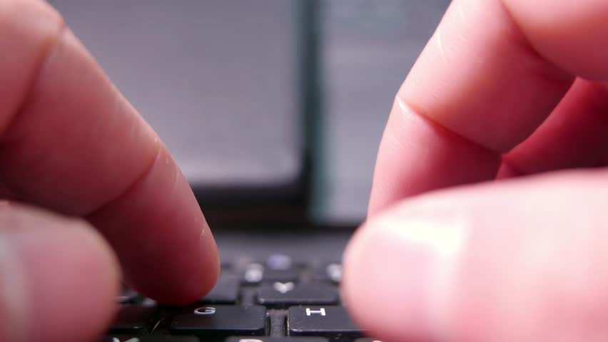 POV (zoom out): hands typing on a computer keyboard. A laptop keyboard. A wireless keyboard. A dusty keyboard. A dirty computer. Writing, close-up.