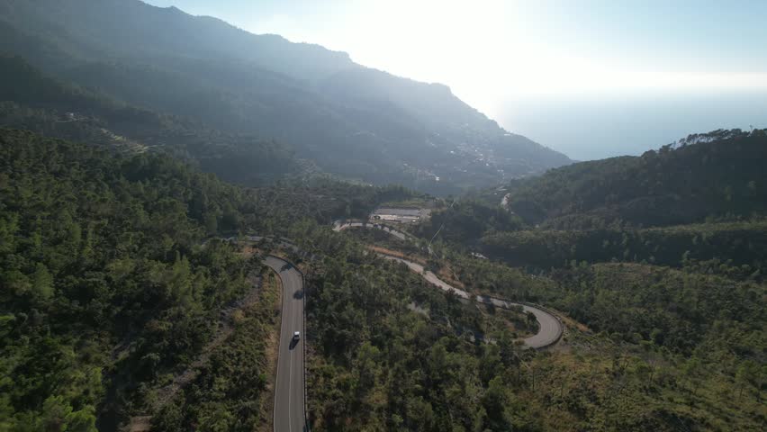 Aerial view of a winding road through the mountainous landscape of Mallorca, Balearic Islands, Spain.