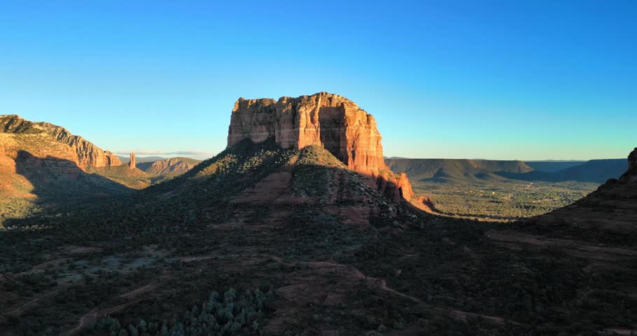 The Iconic Courthouse Butte Rock stands tall in warm afternoon light, casting long shadows across Sedona sprawling desert