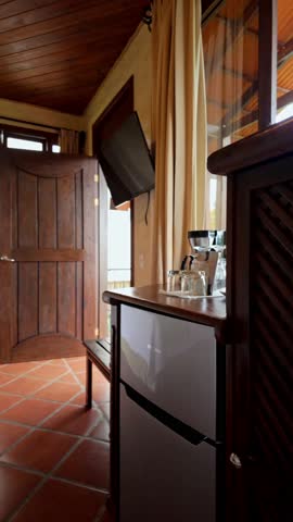 Comfortable rustic hotel room featuring two beds, wooden furniture, and terracotta tiled flooring, providing a warm and inviting atmosphere for travelers seeking a cozy vacation getaway