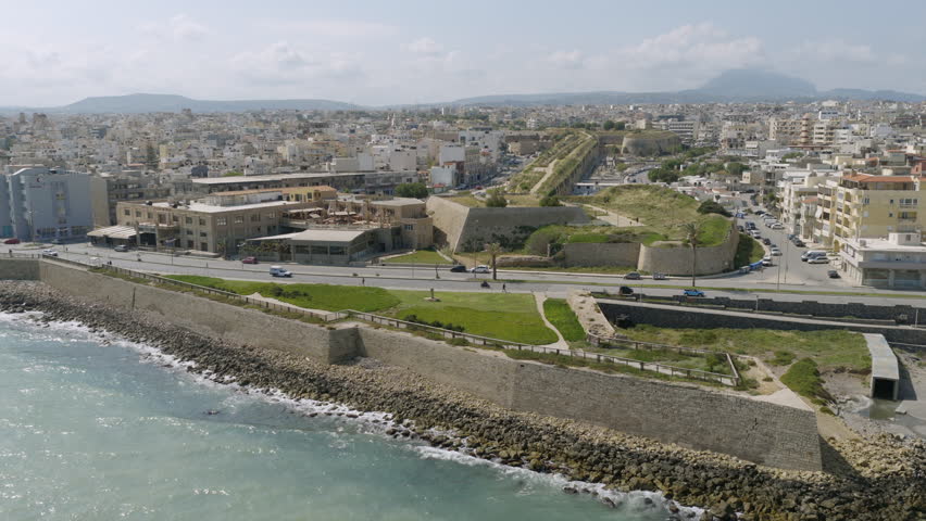 Aerial view of Heraklion, Crete, showing the historic Venetian walls along the rocky shoreline, with the city