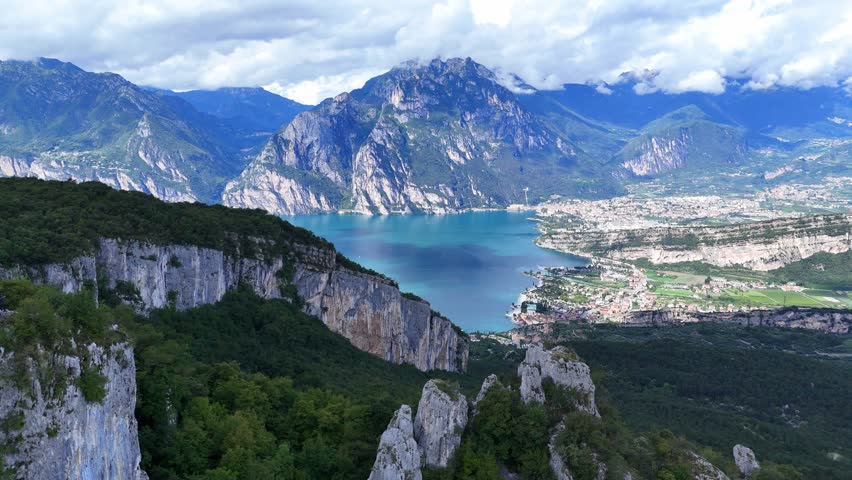 An Aerial view of Riva del Garda with lakeside town, turquoise water, and dramatic Alpine mountains