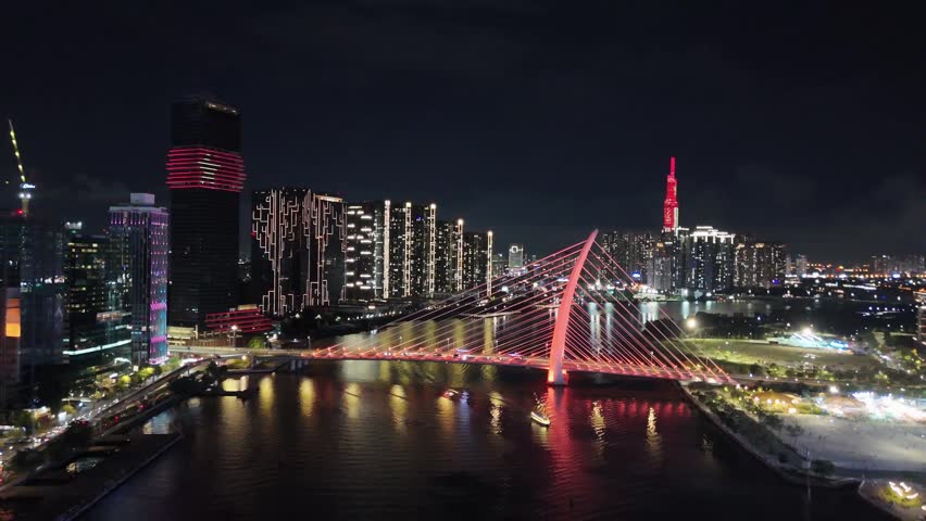 Nighttime aerial view of Saigon river with waterfront and Ba Son Bridge in Ho Chi Minh city, Vietnam.