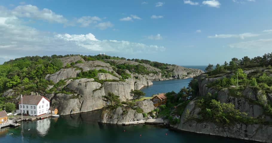 Aerial view of rocky coastal village in Ny Hellesund Norway with boats in slow motion