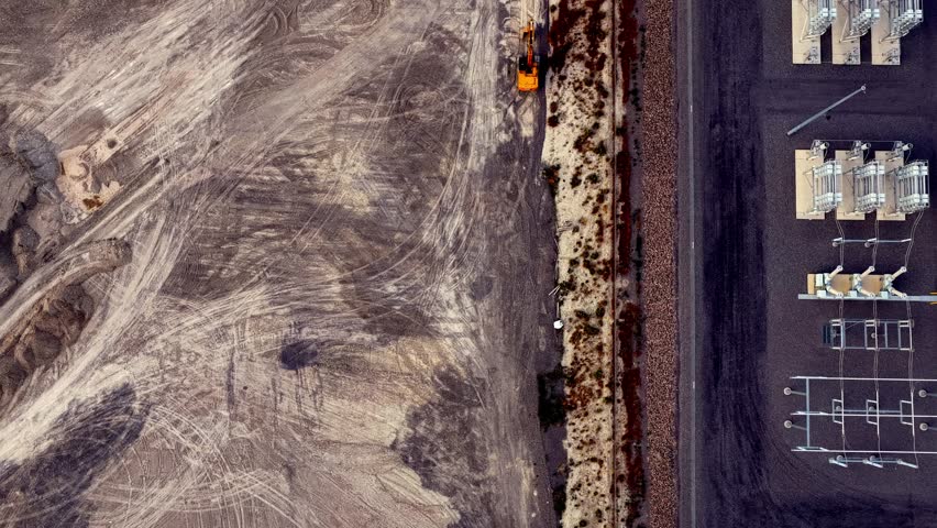 Aerial view of electrical substation components and construction site with heavy machinery in Eagle Mountain, Utah, United States.